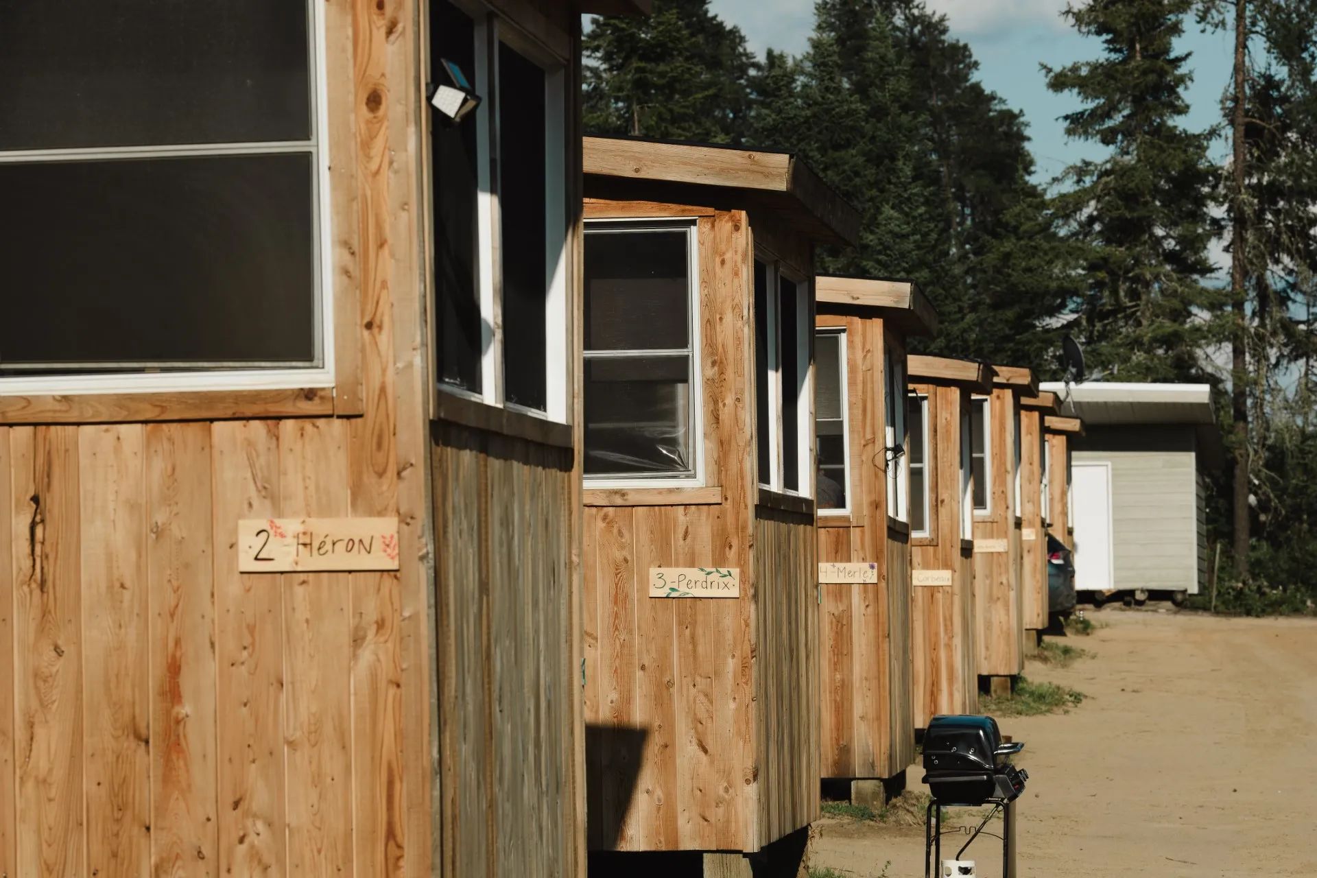 Side view of the wooden cabins numbered and identified by bird names.