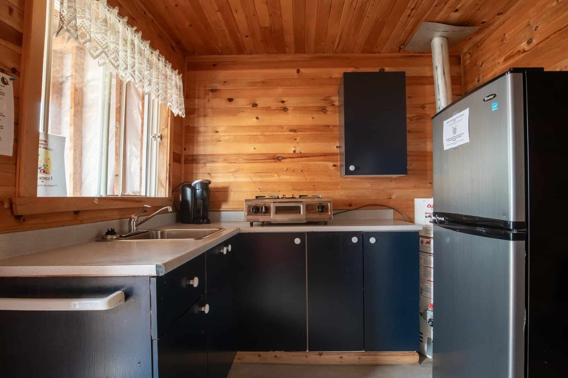 The cabin's functional kitchen is equipped with a refrigerator, a sink, and a stove.