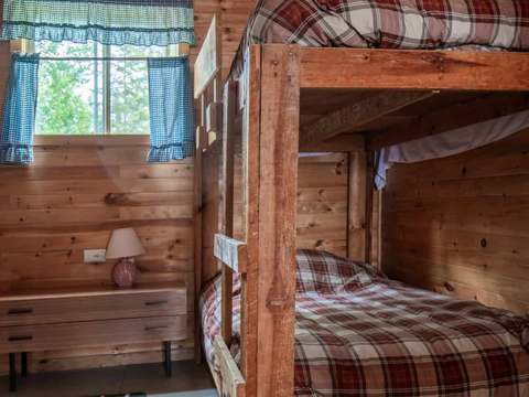 Une chambre avec un lit superposé en bois dans le chalet Perdrix.