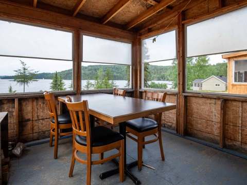 La véranda du chalet Perdrix dispose d'une table à manger avec vue sur le lac.