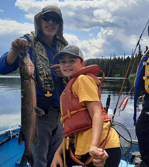 Angler showcasing their catch at La Pourvoirie du Lac Cyprès, Côte-Nord, Quebec