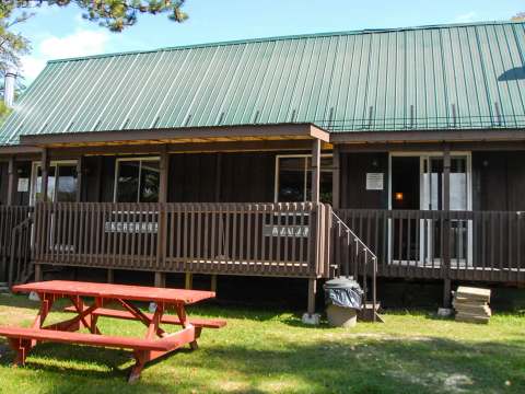 Exterior facade of the Avalanche-Nordique cabin with its porch and picnic table.