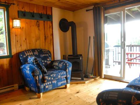 The Avalanche-Nordique cabin living room features a wood stove and comfortable furniture.