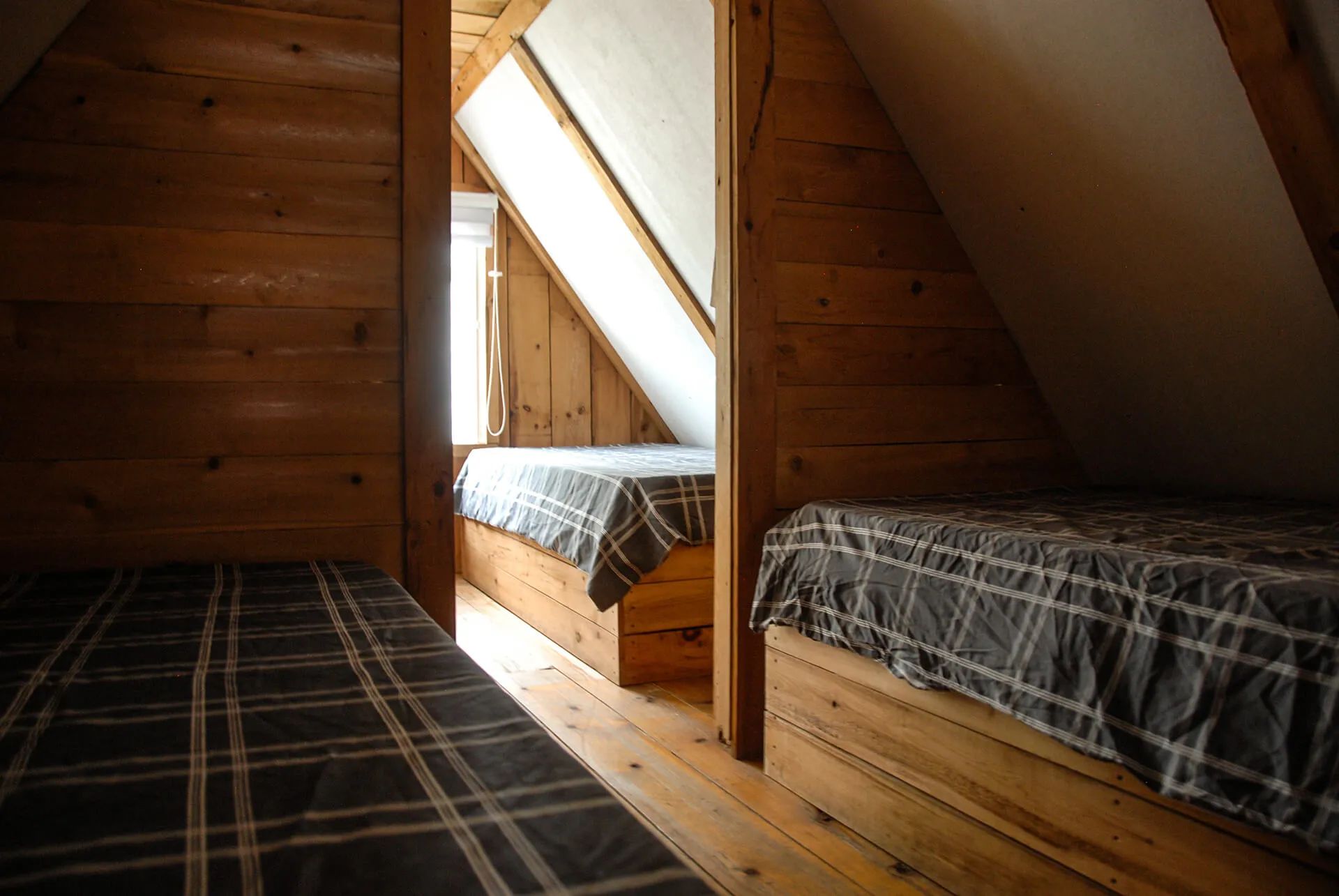 The mezzanine of the Avalanche-Nordique cabin features several single beds under the sloping roof.
