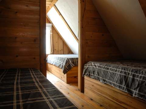 The mezzanine of the Avalanche-Nordique cabin features several single beds under the sloping roof.