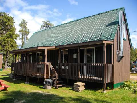 Exterior view of the Avalanche-Nordique cottage with its covered gallery and metal roof.