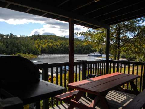 A view of the lake and boats from the covered deck featuring a picnic table.