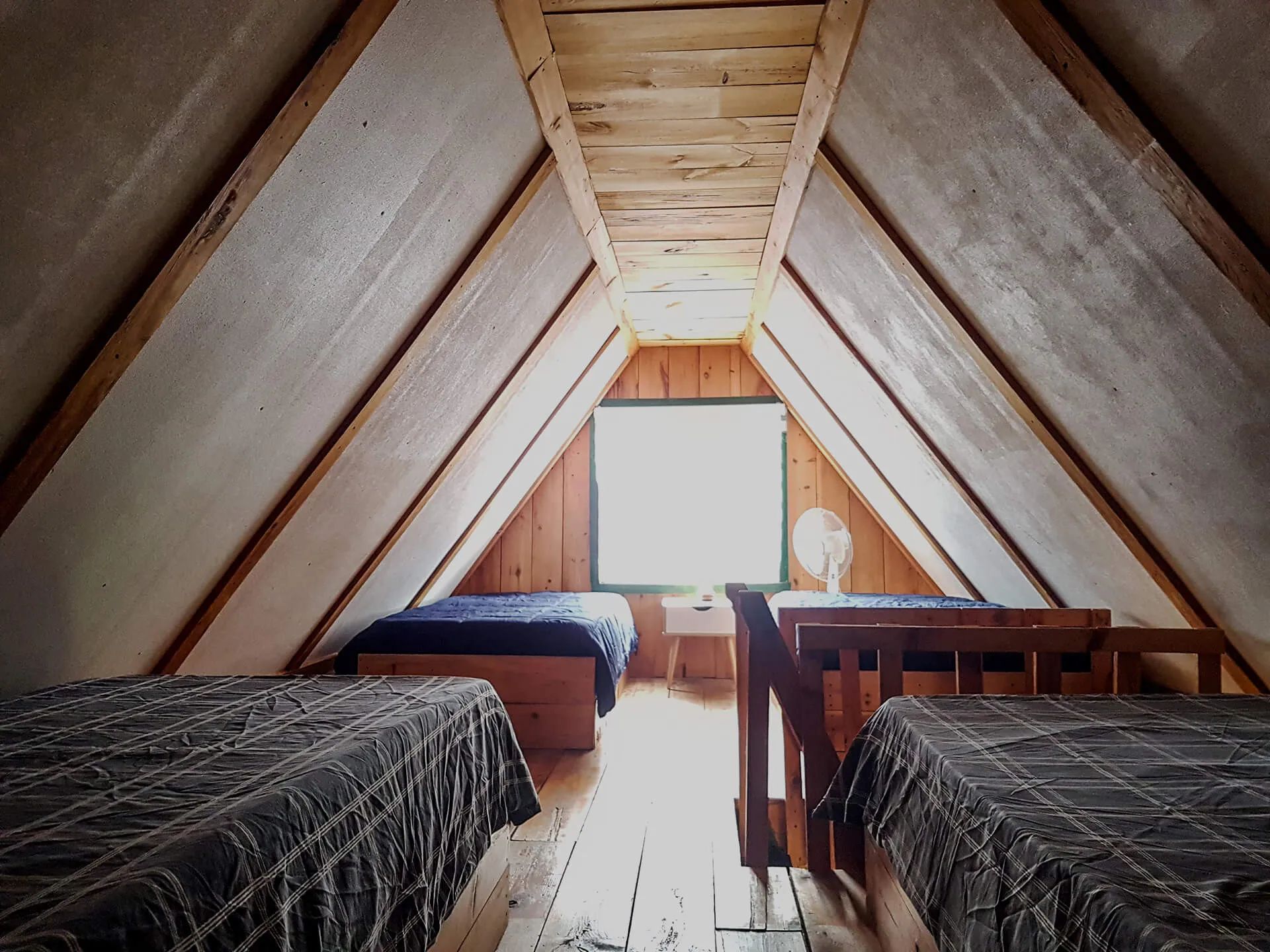 This bedroom under the roof features several rustic-style single beds.