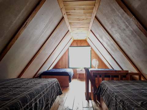 This bedroom under the roof features several rustic-style single beds.