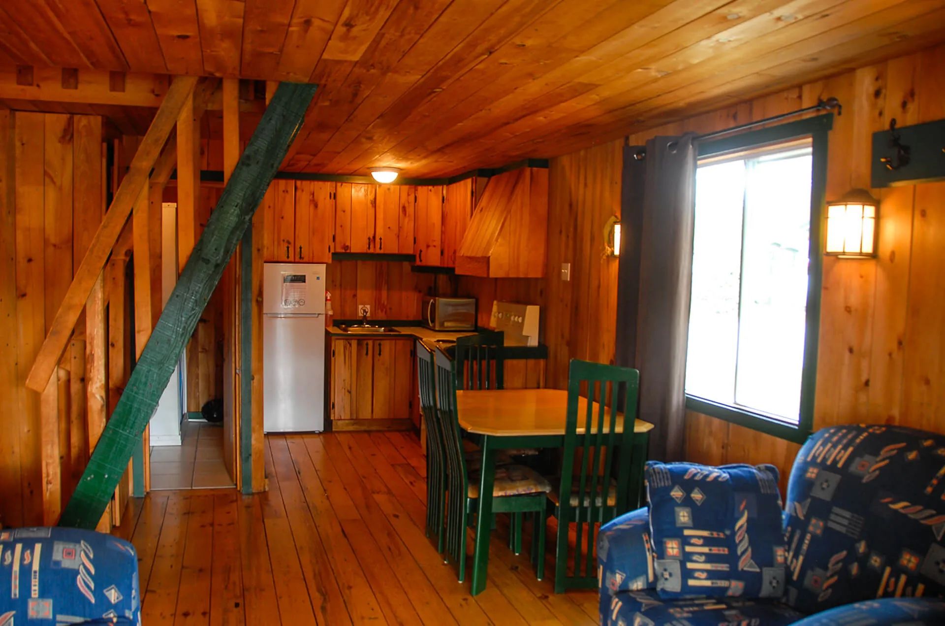 The main living area of the cottage includes a kitchen, a dining table, and a living area.