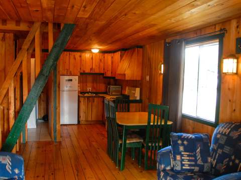 The main living area of the cottage includes a kitchen, a dining table, and a living area.