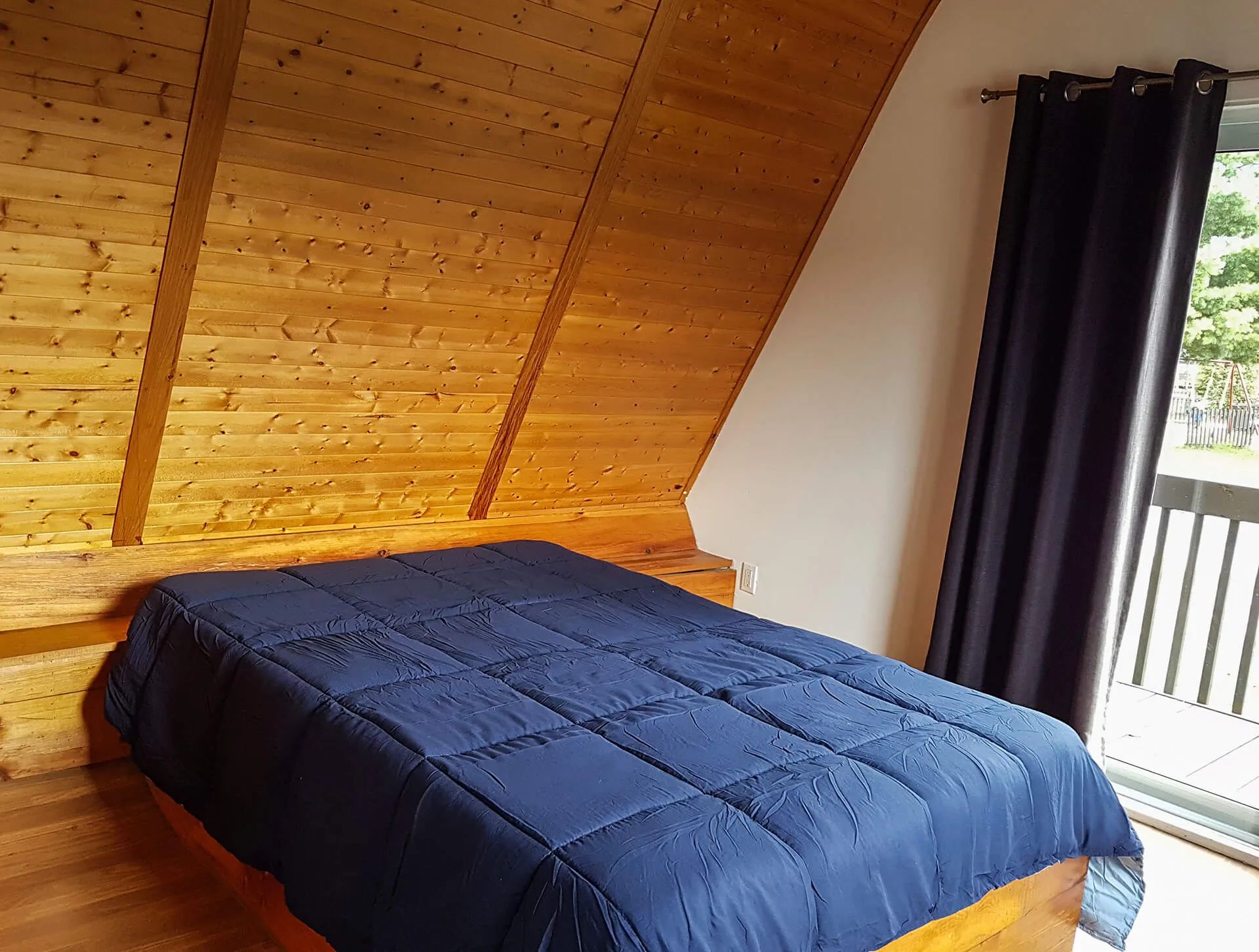This room under the roof features a cozy bed and provides access to a private balcony.