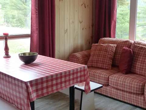 The cabin living area is furnished with a comfortable sofa and a dining area.