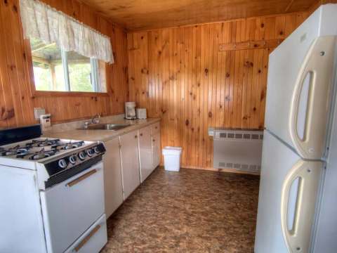 La cuisine équipée du chalet dispose d'une cuisinière, d'un réfrigérateur et d'un comptoir fonctionnel.
