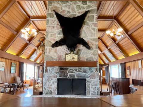 The common living area of the Manoir featuring an impressive stone fireplace and vaulted wooden ceiling.