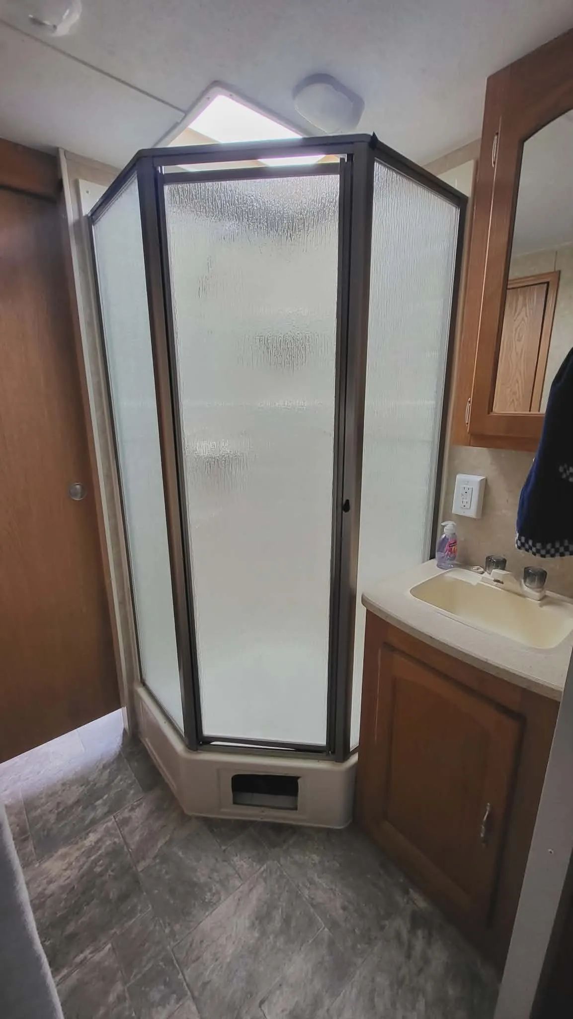 La salle de bain de la roulotte comprend une douche en coin et un lavabo.