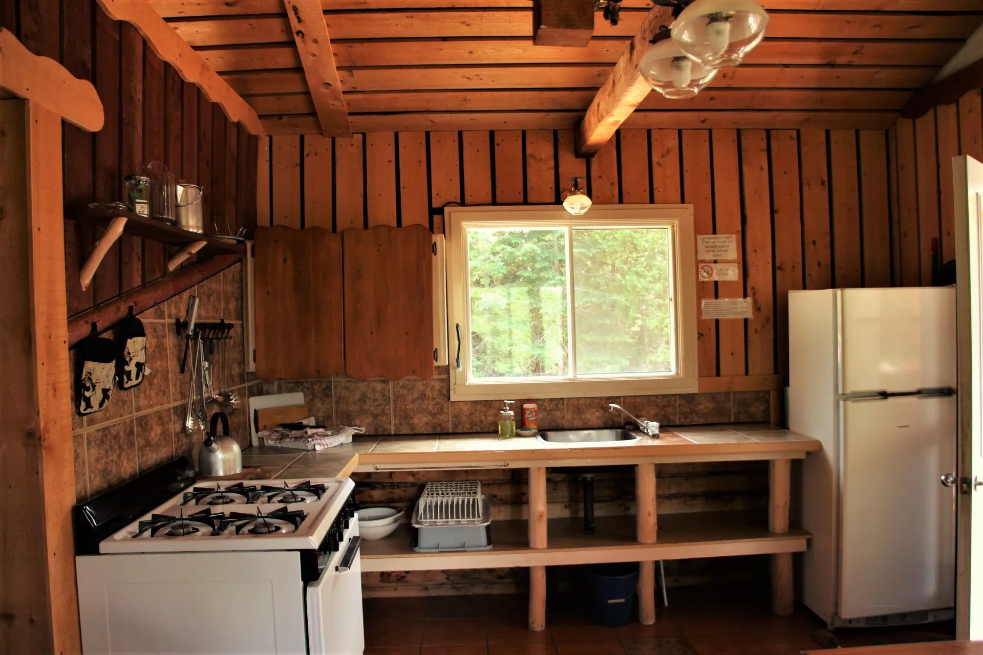 The functional kitchen of the Bellevue cottage is equipped with a stove and a refrigerator.