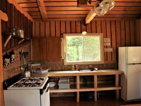 The functional kitchen of the Bellevue cottage is equipped with a stove and a refrigerator.