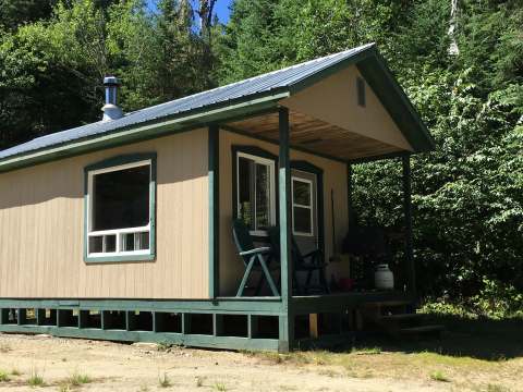 Exterior view of the Alexander cabin with its porch and chairs.