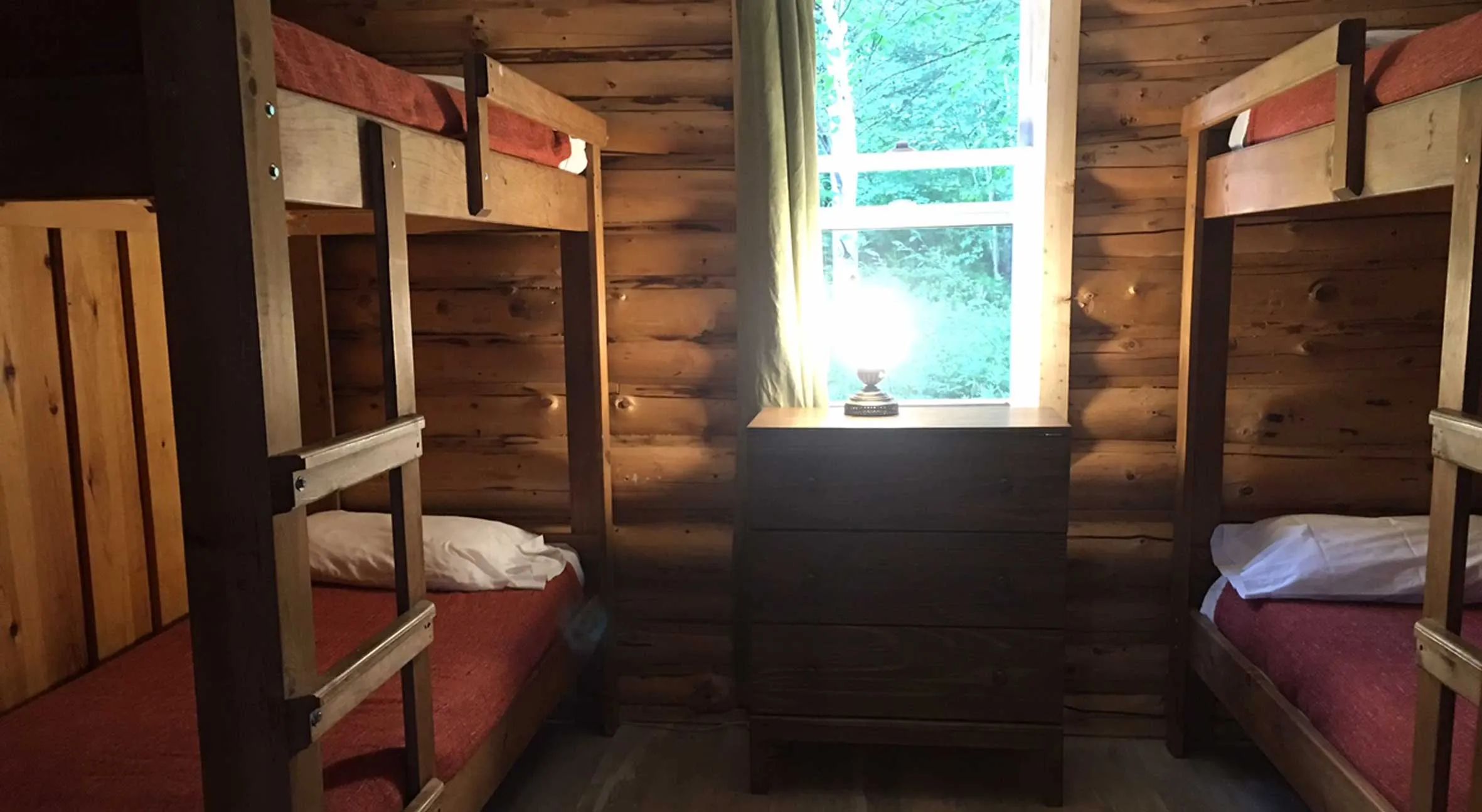 This rustic cabin bedroom features two wooden bunk beds.