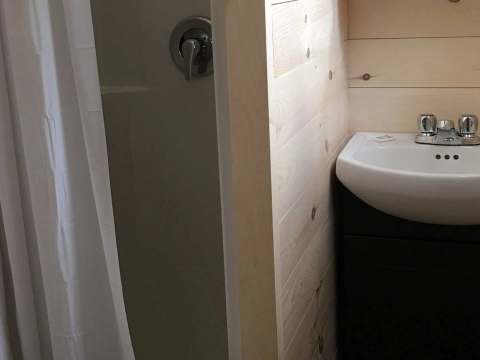 This functional bathroom is equipped with a sink and a shower.