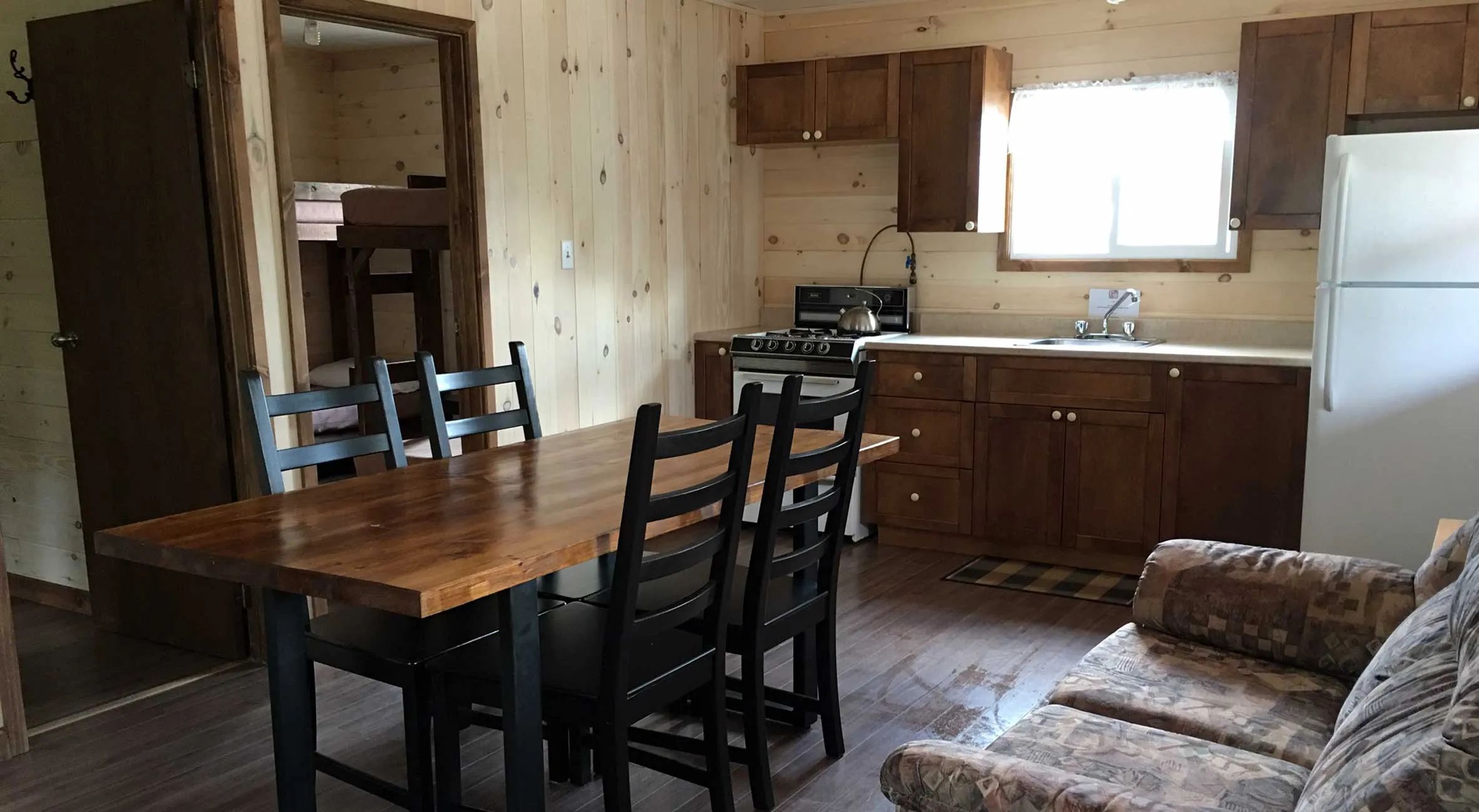 View of the kitchen area and dining room inside a fully equipped cabin.