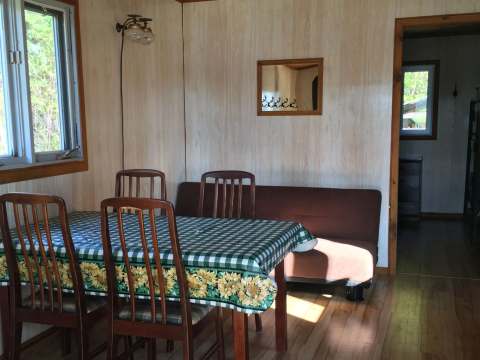 The cottage dining area features a table with chairs and a sofa bed.