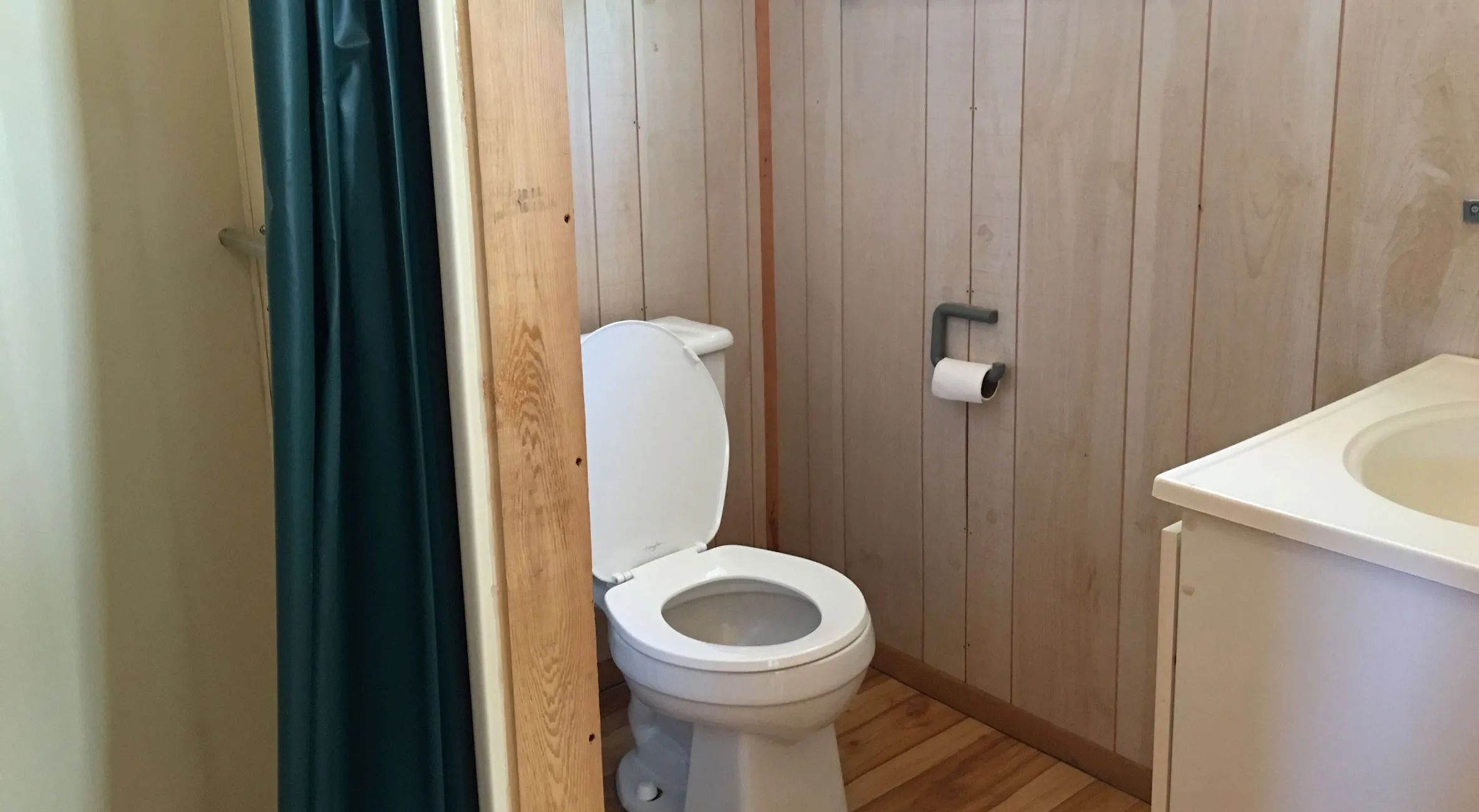 View of the functional bathroom including a toilet and a sink in the Sloe cabin.