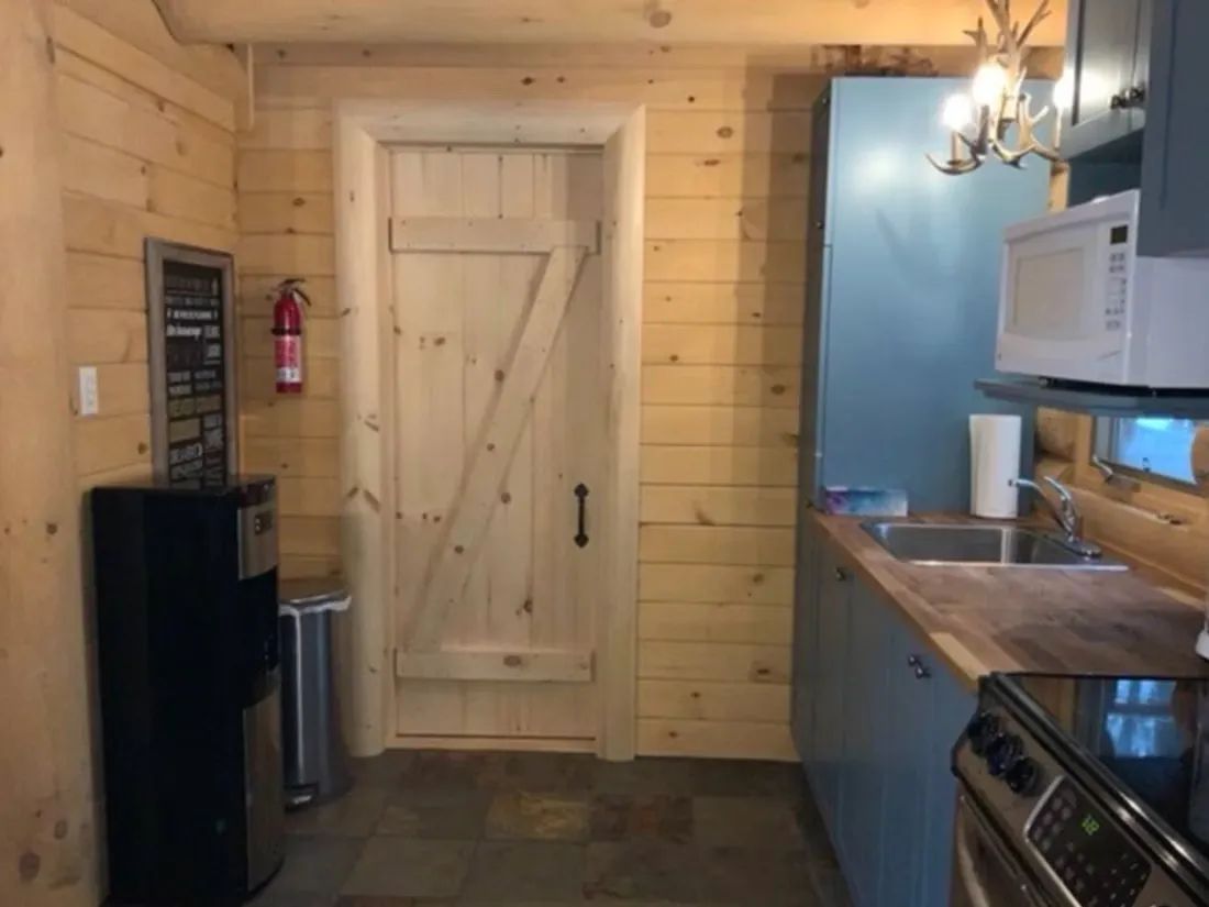 La cuisine fonctionnelle du chalet L'Amer est aménagée avec des armoires bleues et du bois naturel.