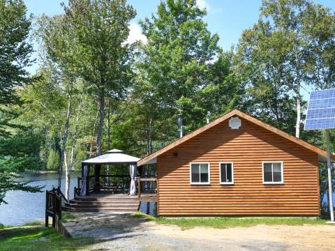 The log chalet number 9 with its covered terrace and view of the lake.