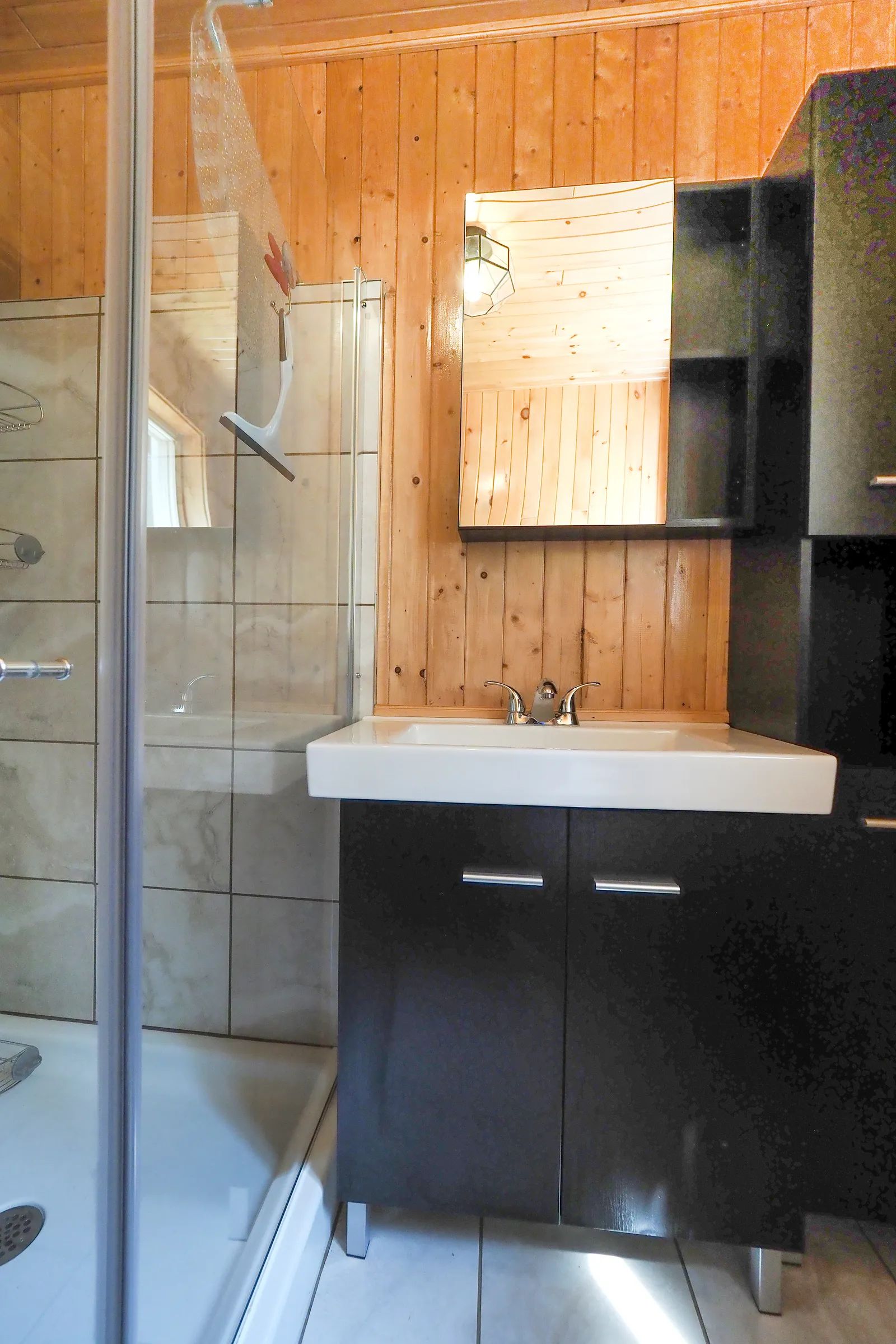The cottage bathroom features a glass shower and a modern vanity.
