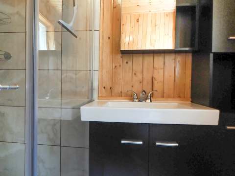 The cottage bathroom features a glass shower and a modern vanity.