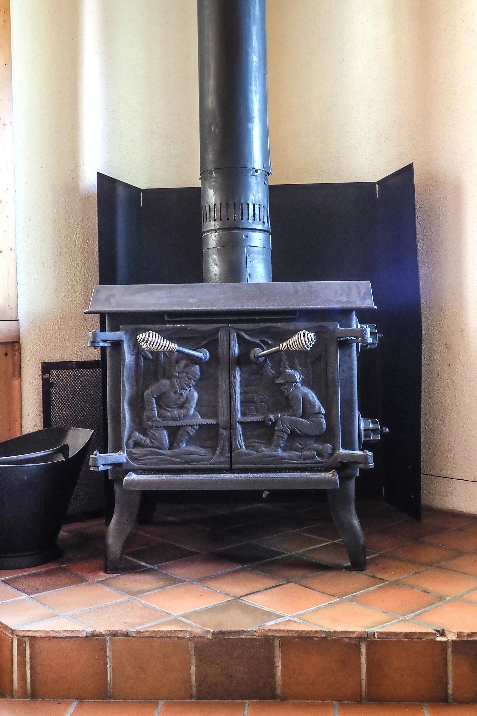 A cast iron wood stove decorates the cottage living room for a warm atmosphere.