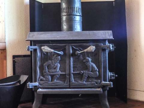 A cast iron wood stove decorates the cottage living room for a warm atmosphere.