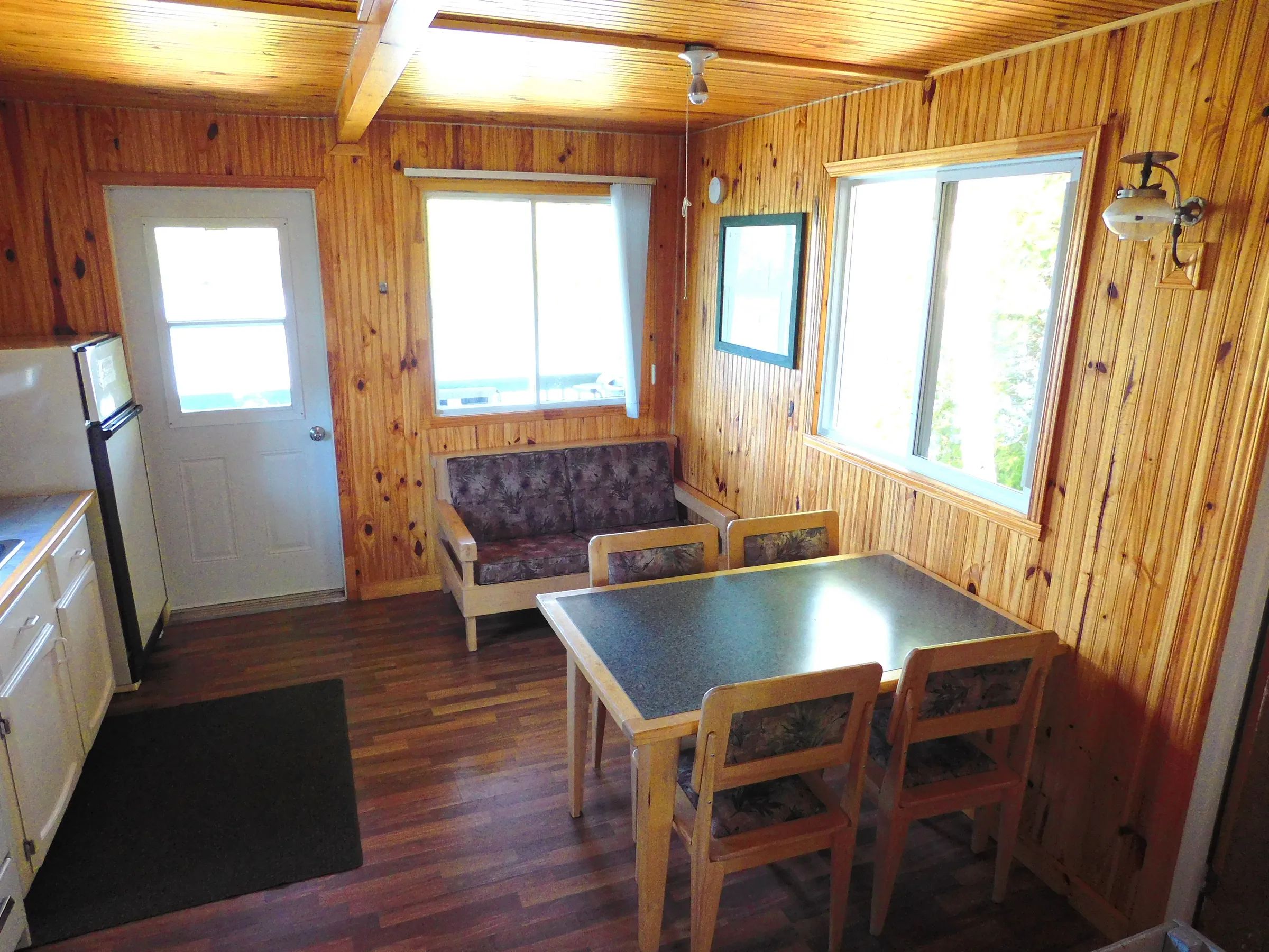 Vue de l'espace de vie comprenant une table à manger et un coin salon dans le chalet classique.