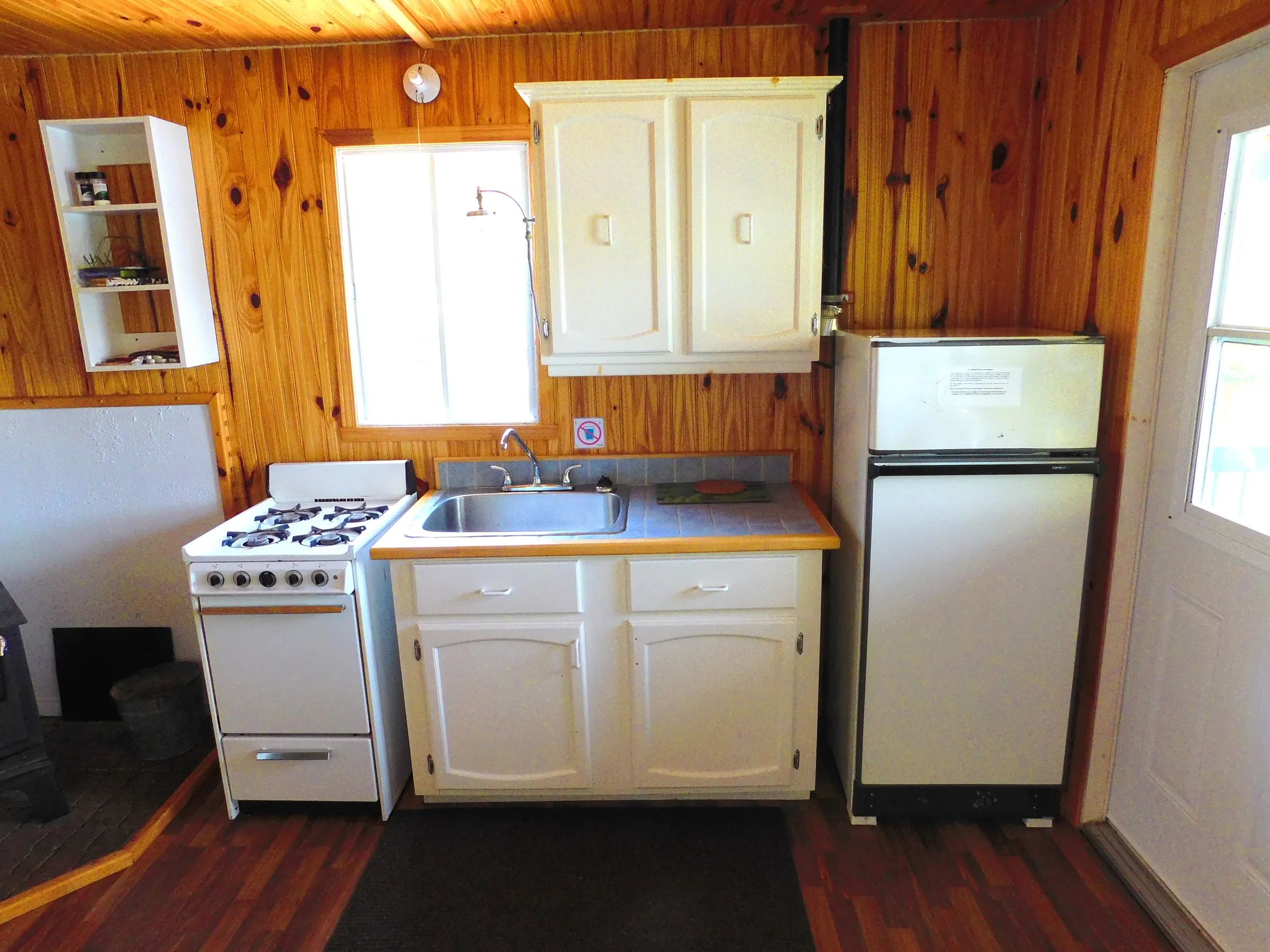 La cuisine du chalet est équipée d'une cuisinière, d'un évier et d'un réfrigérateur.