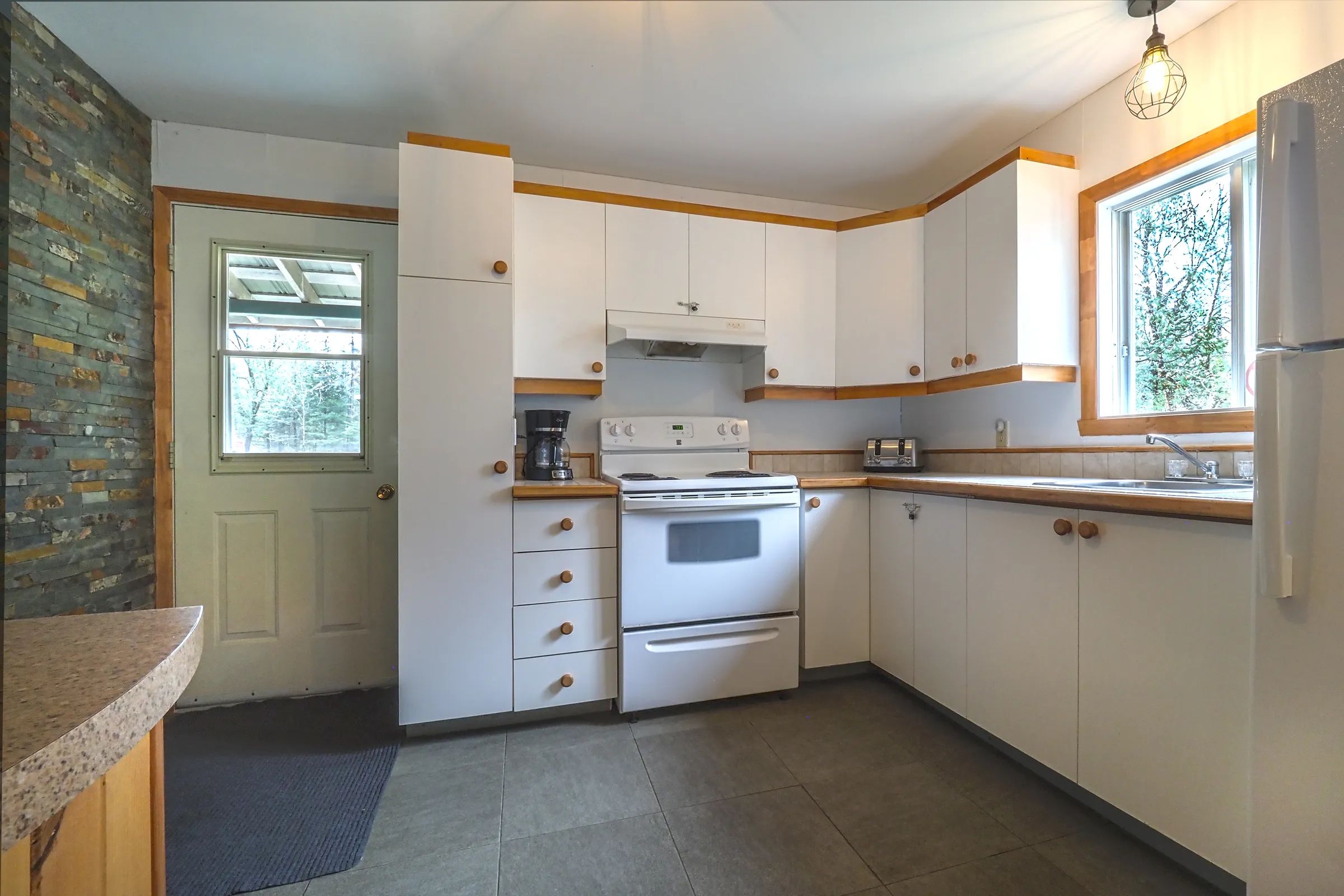 The chalet's equipped kitchen features white cabinets and full appliances.