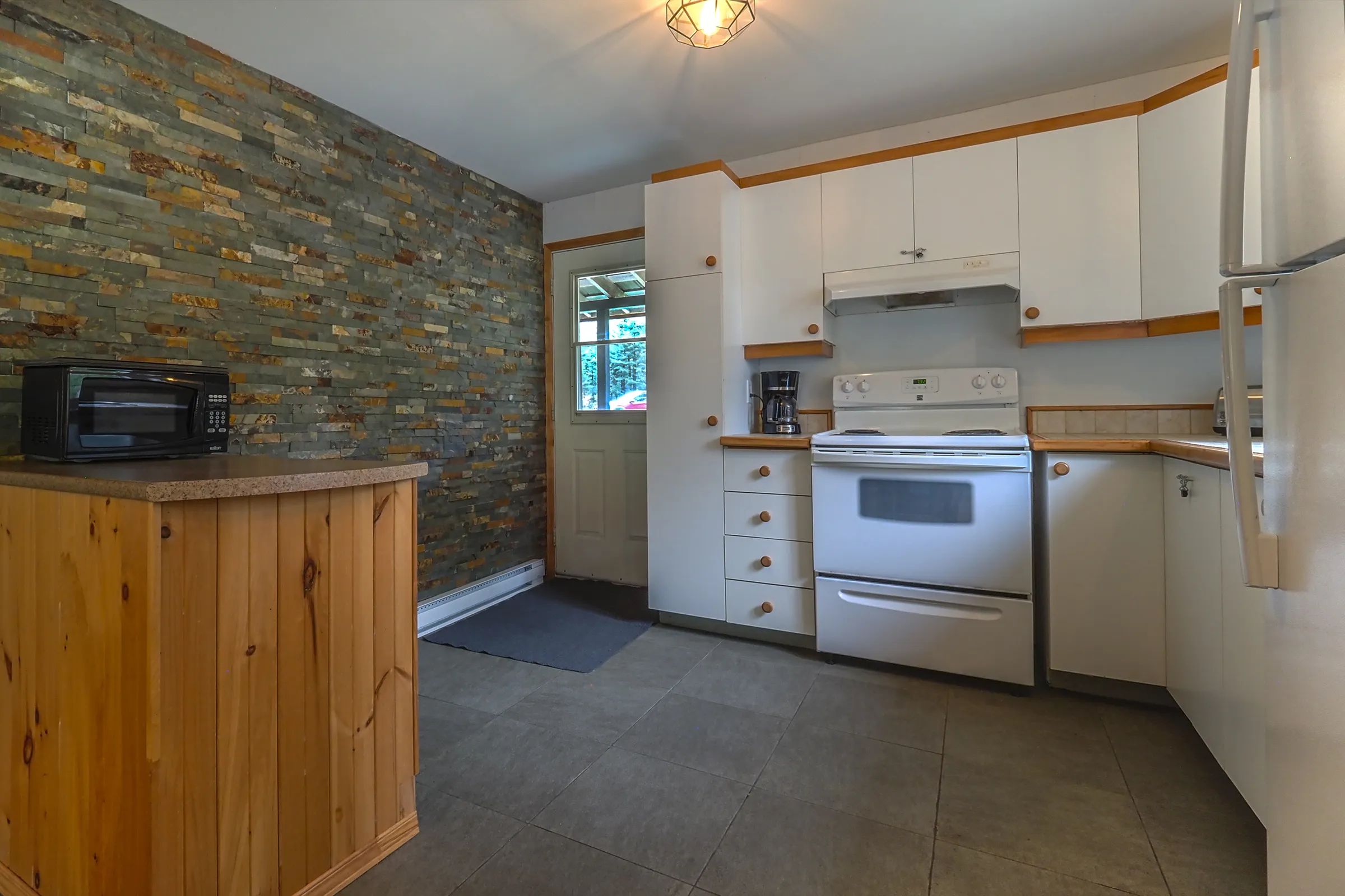 The cottage's equipped kitchen includes a stove, microwave, and wooden cabinets.