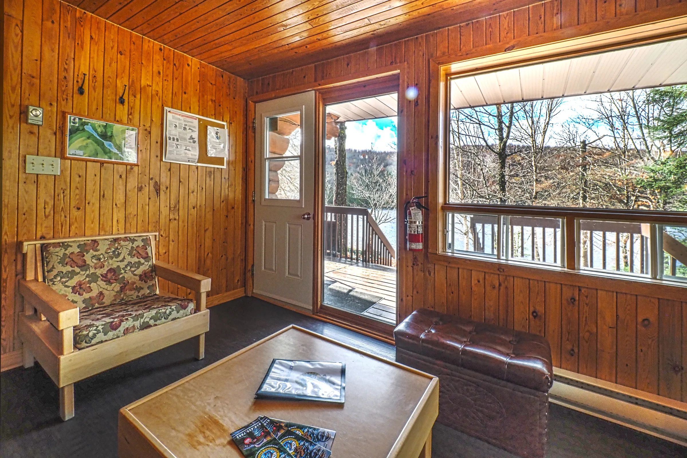 The chalet living area offers a direct view of the outdoor deck and the water.