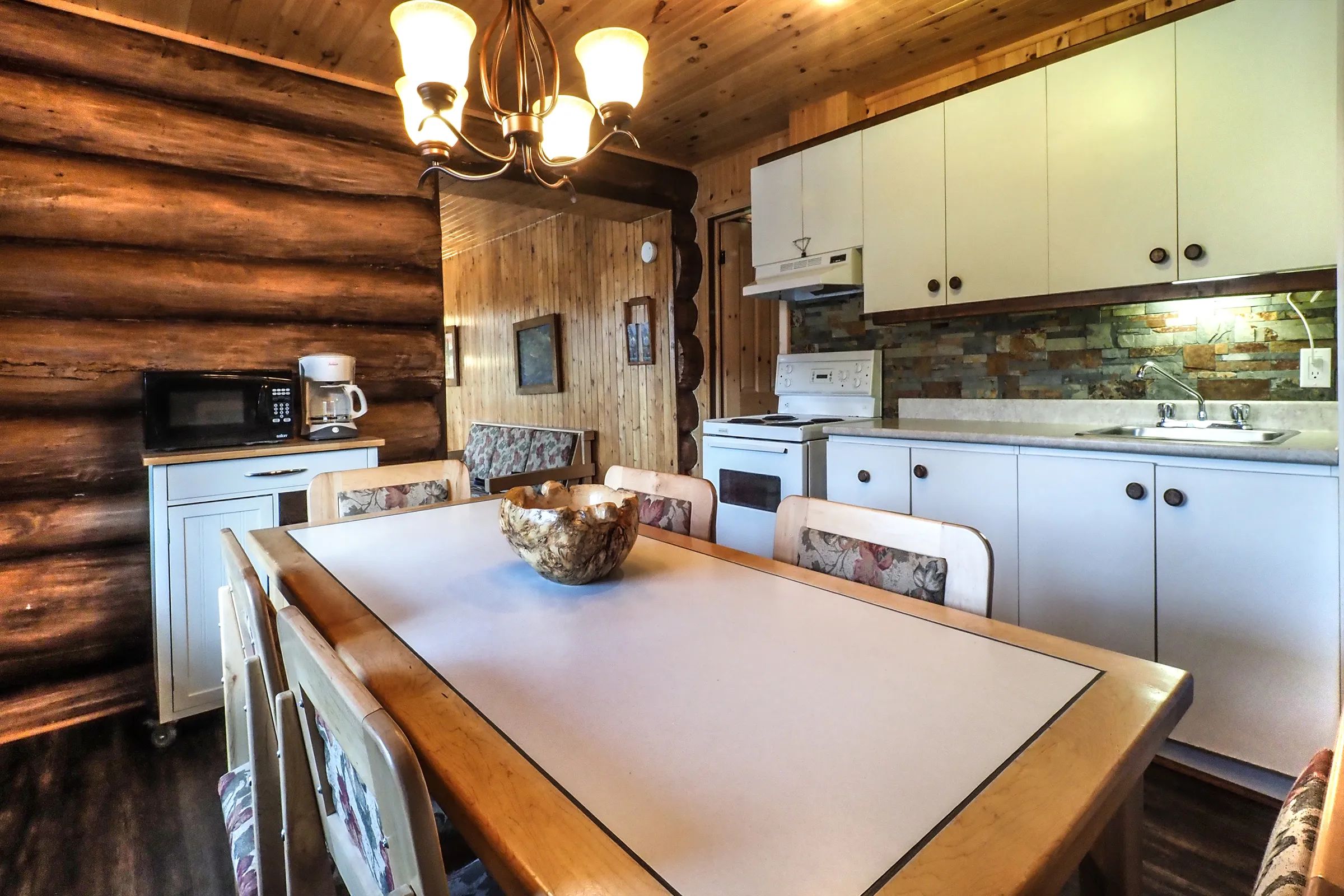 This equipped kitchen and dining area are located inside the cabin.
