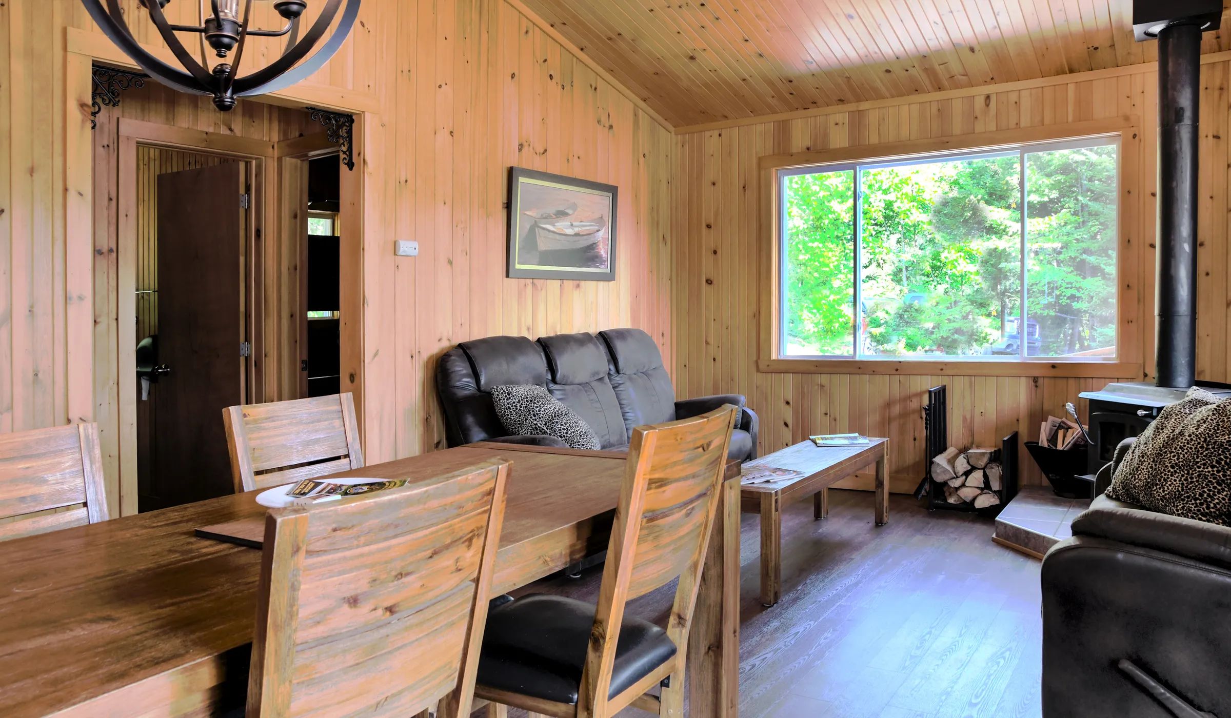 The chalet's dining and living area features wooden furniture and a fireplace.