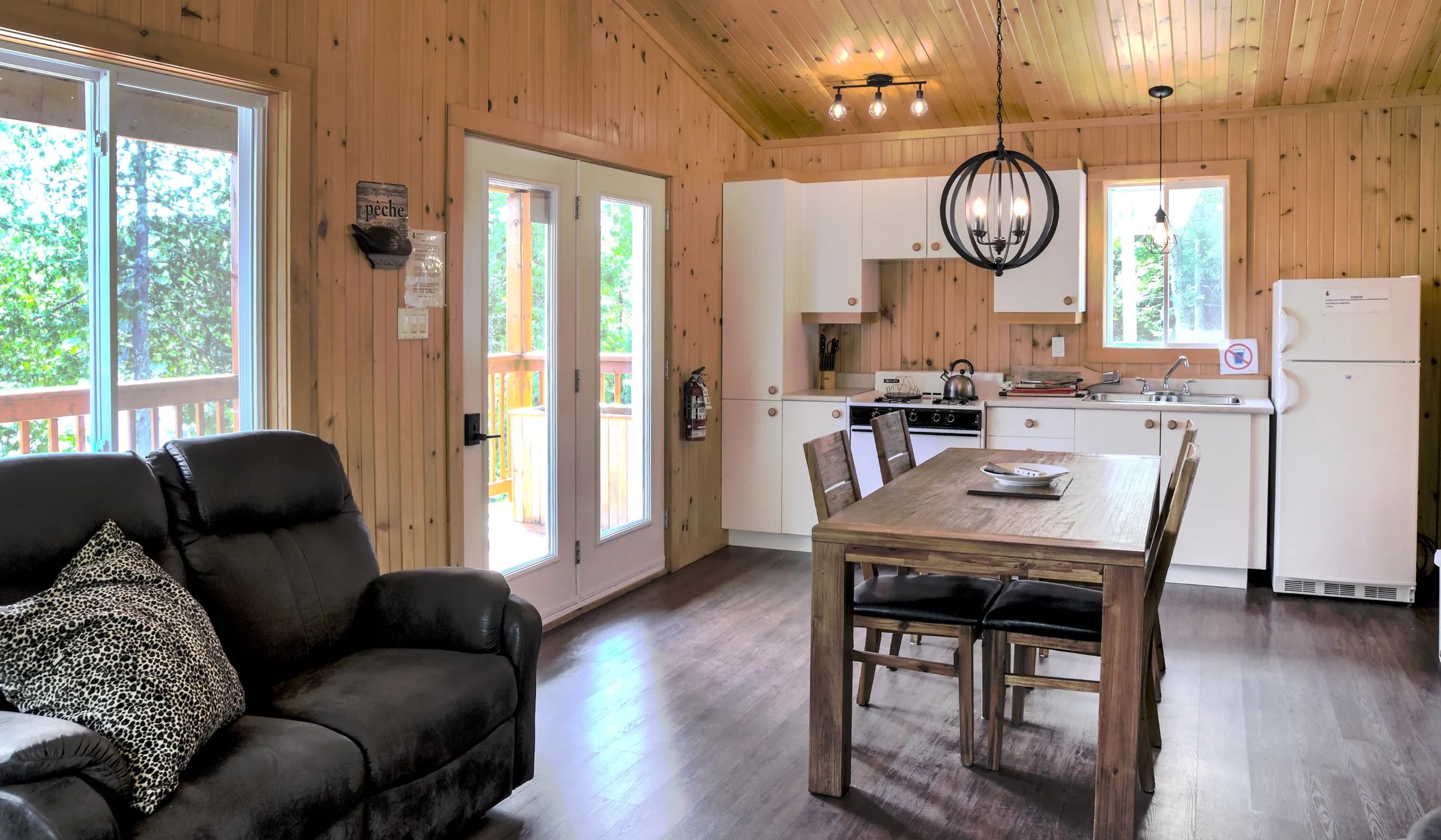 This open area includes a fully equipped kitchen, a dining table, and a living room with a sofa.
