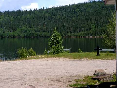 Vue sur le lac et la forêt depuis l'extérieur du chalet.