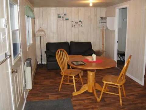 L'aire commune du chalet comprend une table à manger et un petit canapé.