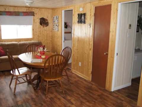 The cottage dining and living area features a table with chairs and a sofa.
