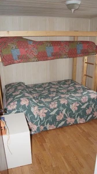 This cabin bedroom features a bunk bed with floral and colorful patterned bedding.