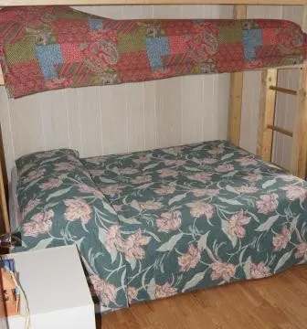 This cabin bedroom features a bunk bed with floral and colorful patterned bedding.