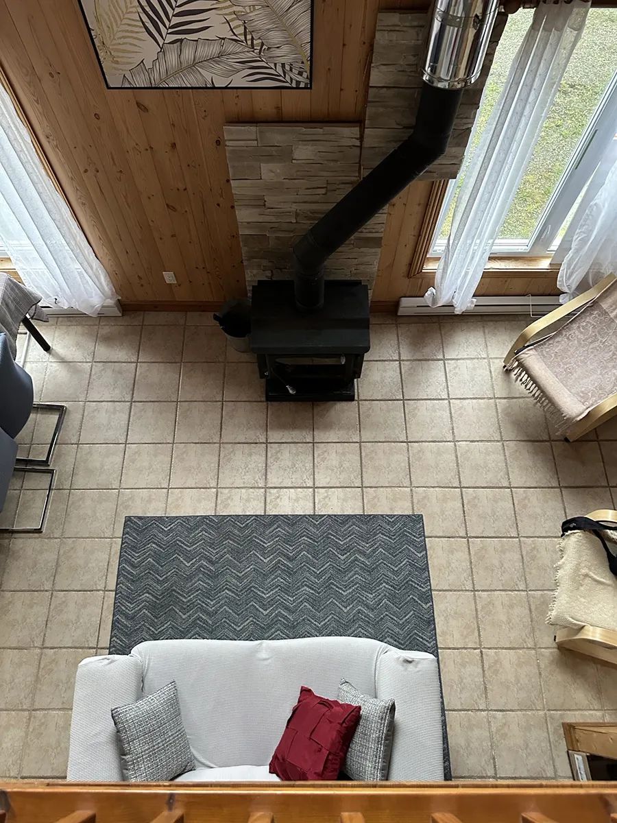 The cottage living area features a wood stove and a comfortable space to relax.