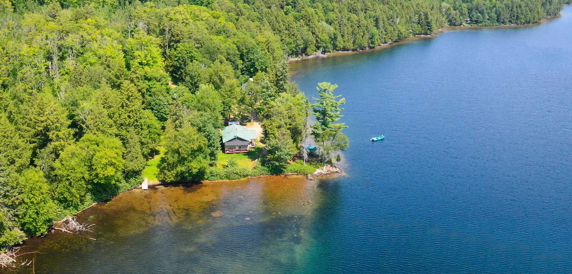 Le chalet Le Coureur des bois est situé en bordure de lac dans un environnement boisé.