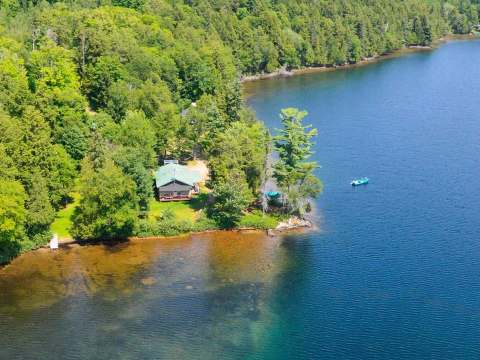 Le chalet Le Coureur des bois est situé en bordure de lac dans un environnement boisé.